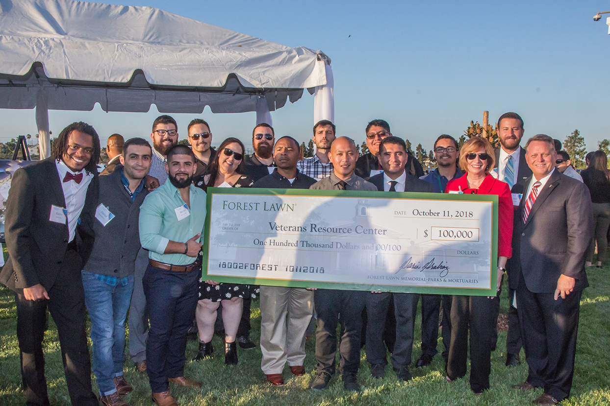 Cypress College President Dr. Schilling and student veterans accept a $100,000 check from Forest Lawn to support the VRC