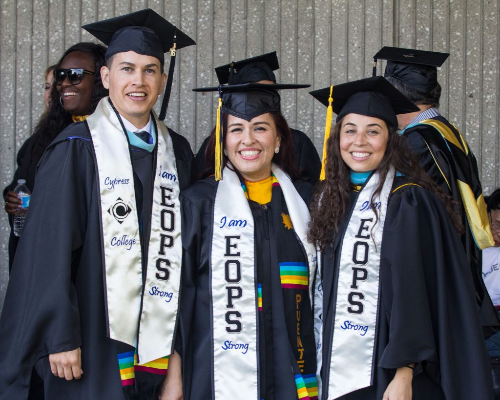 People in graduation caps and gowns standing together 