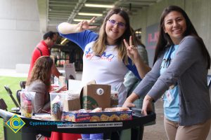 Kassandra Abreu smiling with another young woman giving the peace signs.