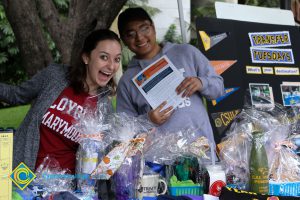 A young woman with Loyola Marymount t-shirt and young man in a grey sweatshirt smiling.