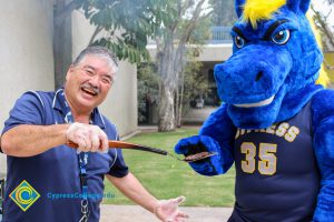 David Okawa giving a hamburger patty to Charlie the Charger