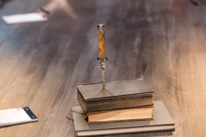 Stack of books pierced with a pocket knife.