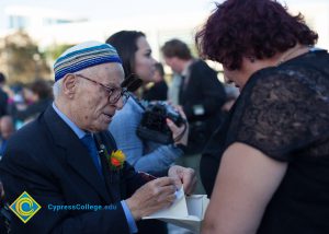 Holocaust survivor, Jacob Eisenbach, signing a book.