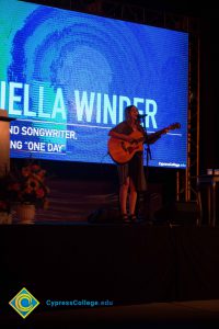 Aviella Winder playing guitar at the 2016 Yom HaShoah event.