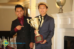 Two male students wearing suits and ties, holding the Cypress College Associated Students Club of the Year award