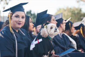 Graduate with her dog during commencement.