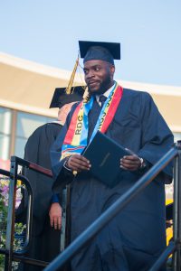 Graduate holding diploma.