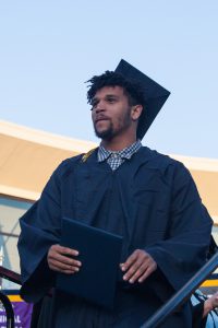 Graduate holding diploma.