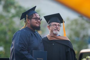 Graduate with professor at commencement.