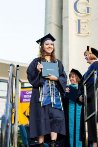 Graduate holding diploma.