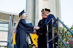 President, JoAnna Schilling congratulating a graduate.