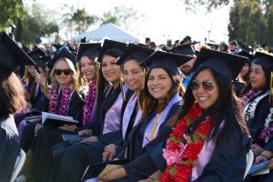 Graduates smiling during commencement.