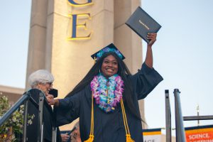 Graduate holding up diploma.