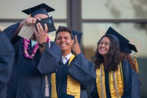 Smiling students wearing cap and gown