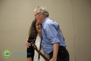 President, Bob Simpson hugging a woman with curly hair.