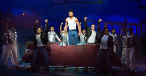 A group of young men performing a scene from Grease.