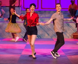 Theater students performing a scene from Grease.