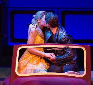Theater students kissing in a scene from Grease.