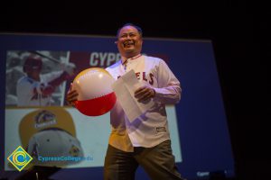 Paul de Dios holding a beach ball while promoting Cypress Day at Angel Stadium.