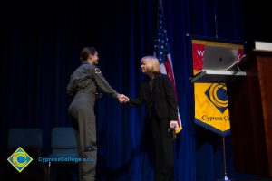 Dr. Schilling shaking hands with a young woman at Fall Opening Day