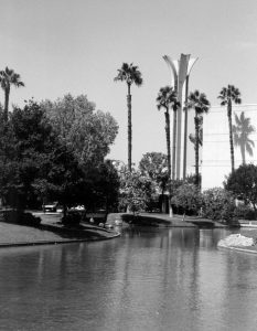 Black and white photo of the pond with trees and the campanile in the background.