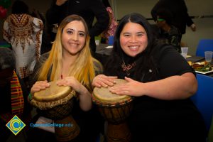 Two smiling students with African drums.