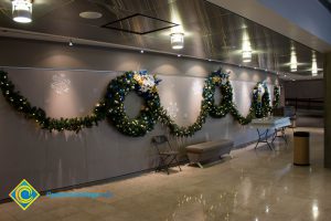 Christmas wreaths and garland decorations hanging in theater lobby.
