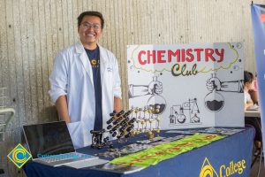 Smiling young man at Chemistry Club display table at Club Rush