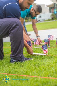 Two gentlemen placing flags on the campus lawn