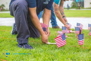 Two gentlemen placing flags on the campus lawn