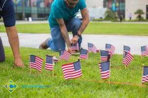 Two gentlemen placing flags on the campus lawn