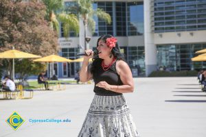 Woman with flower in her hair singing.