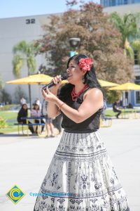 Woman with flower in her hair singing.