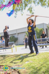 Blindfolded student hitting piñata.