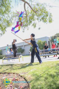 Blindfolded student hitting piñata.