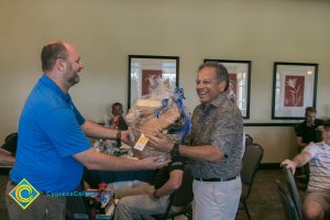 Marc Posner handing a smiling man a basket of goodies.