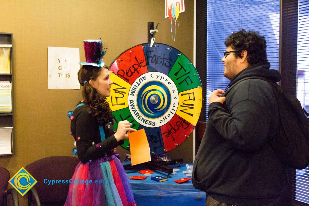 Summer Justice talking to a student at the spin wheel