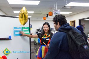 Woman in clown costume talking to a student