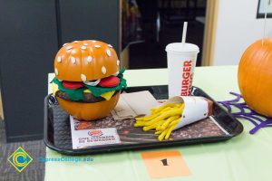 Pumpking cut to look like a hamburger with fake meat, lettuce, tomato, chees and onion with drink and fries