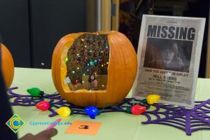 Pumpkin cut open with Christmas lights inside and a Missing child sign on the table