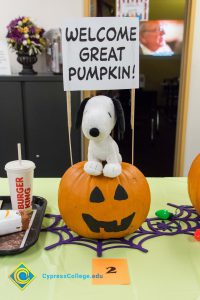Pumpkin with stuffed snoopy sitting on top and sign "Welcome Great Pumpkin"