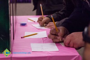 Closeup of students writing on notecards