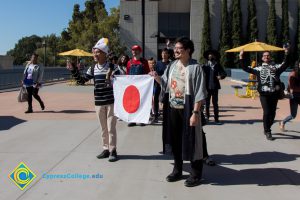 Students dressed as characters from Mario Bros. with flag of Japan