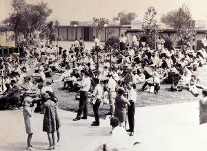 Black and white photo of opening day at Cypress College with students standing and sitting in the quad area.