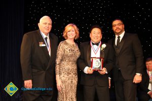 Dr. JoAnna Schilling with three men in suits and tie.