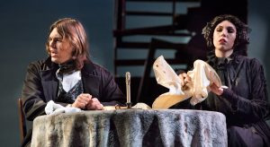 Male and female student sitting at table during a performance of Oliver Twist