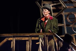 Student on stage, dressed for Oliver Twist play