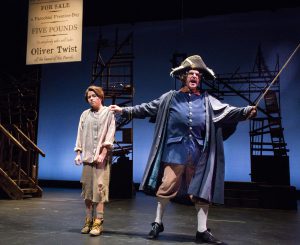 Students performing on stage in Oliver Twist play
