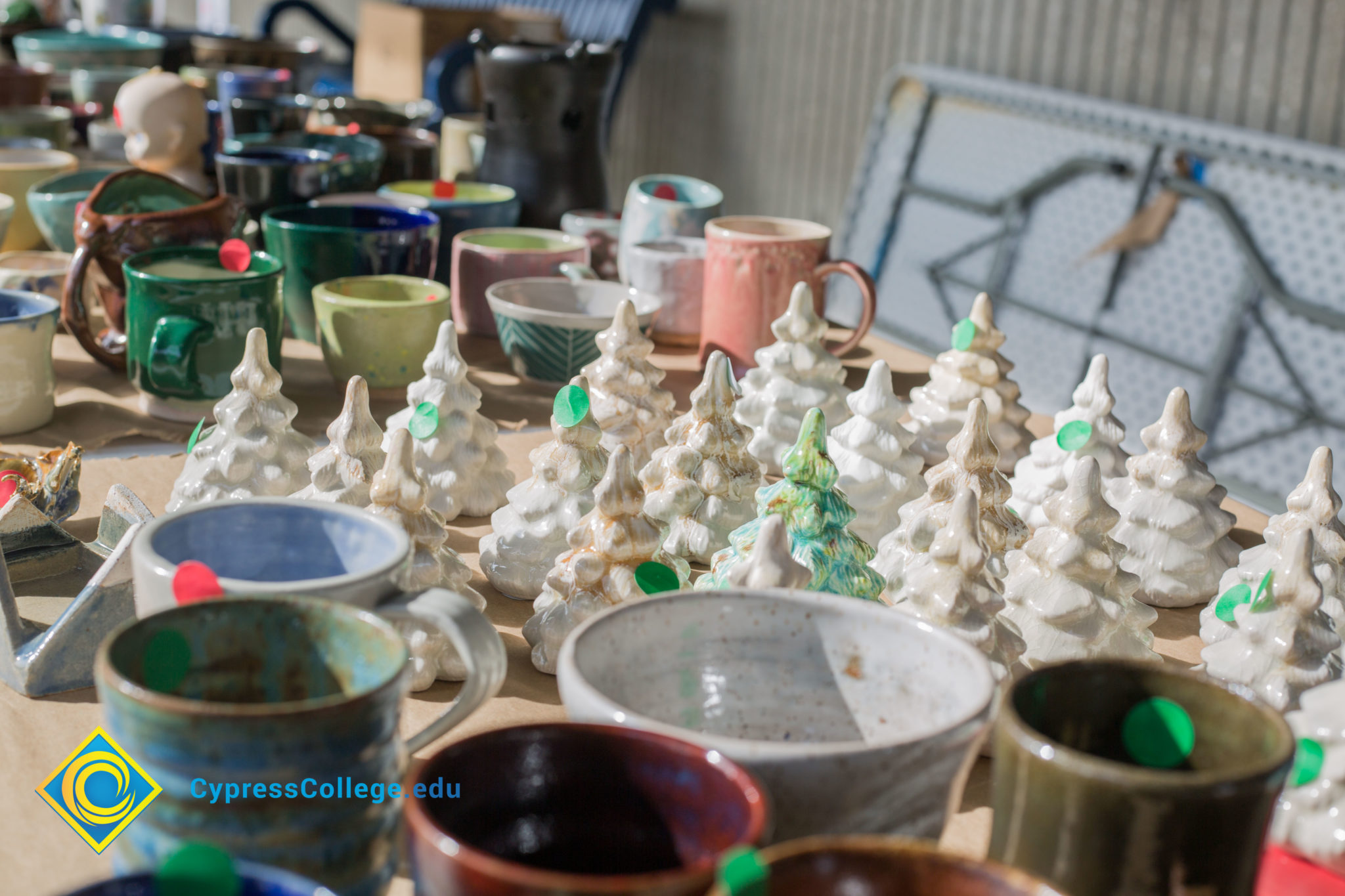 Ceramic Christmas trees and cups on display.