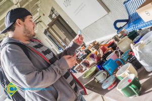 Student looking at ceramic items on display table.